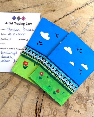 Kaartjes met geweven bandjes. Lucht, veld met bloemetjes en schaapjes