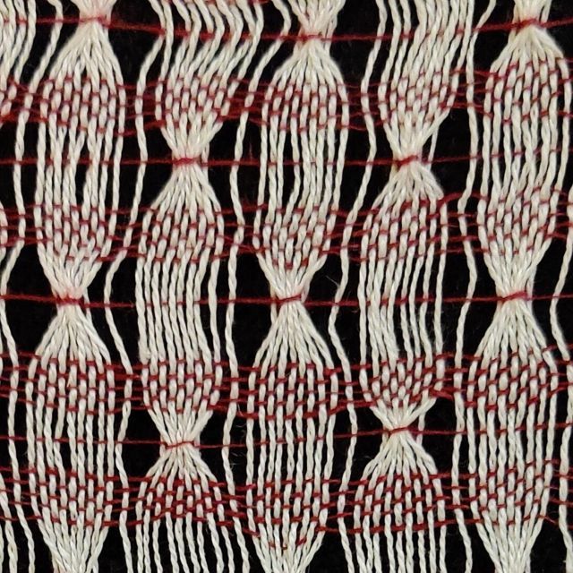 weefsel met smalle en brede witte banen en rode inslag