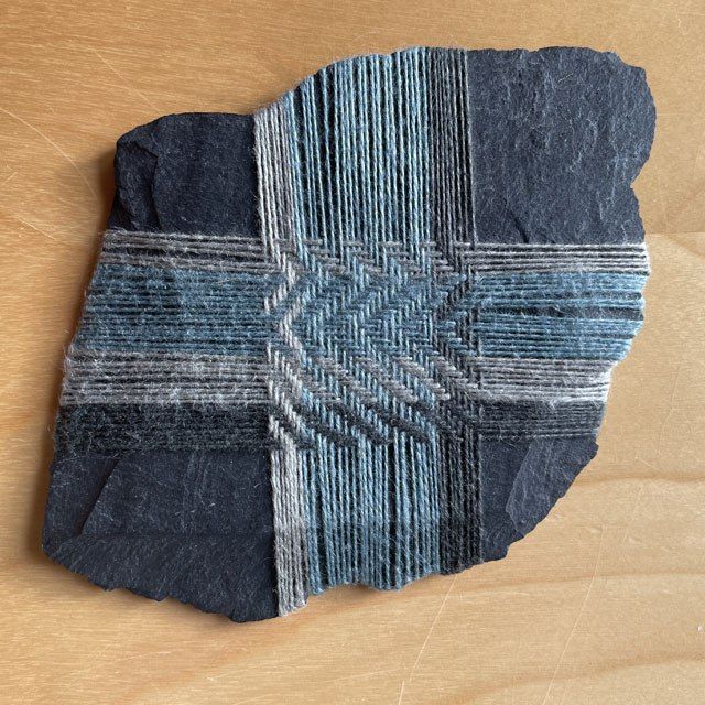 grijs en blauw weefsel om een stuk leisteen