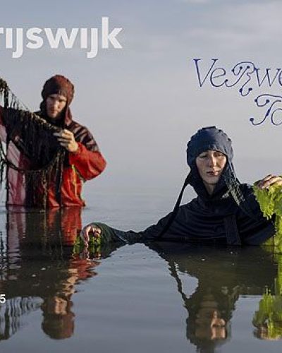 twee mensen staan in het water er bekijken wat ze in hun handen hebben